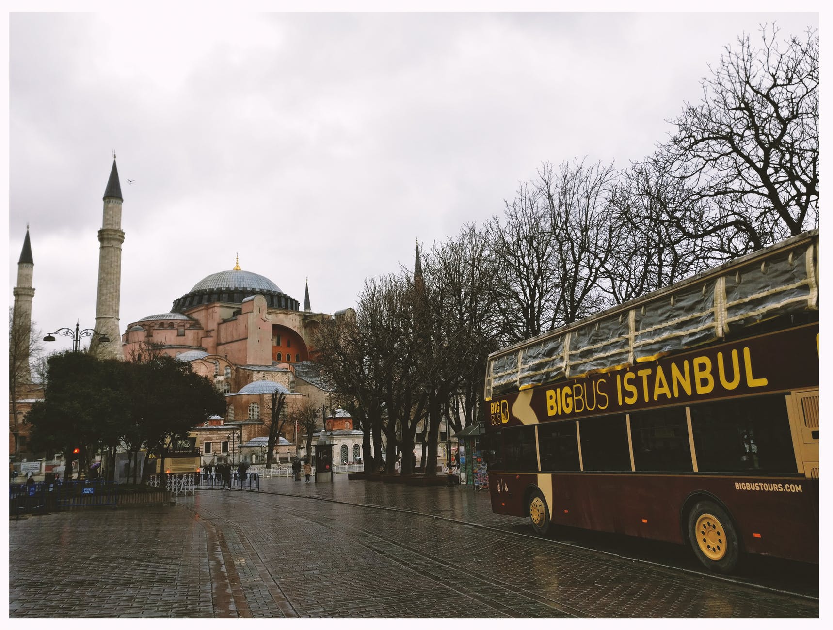 brown bigbus istanbul traveling on road near brown dome building